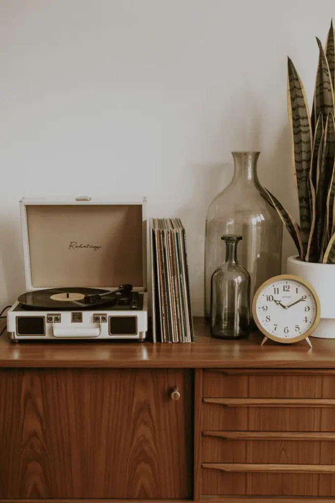 Thrifted vintage treasures including record player, vinyl, antique clock, and glassware.