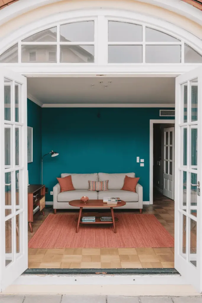 Colorful living room using teal wall and coral rug for bold color blocking design